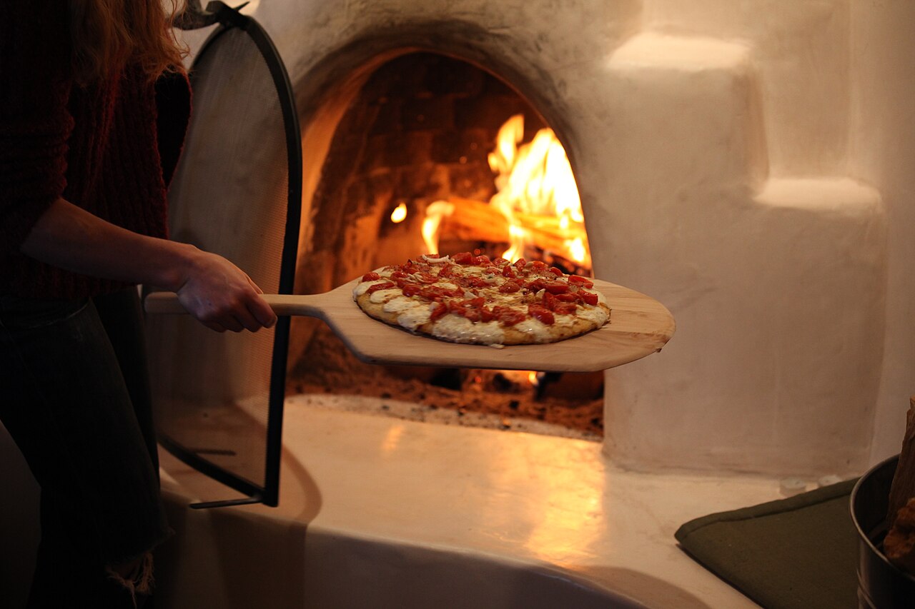 Il pizzaiolo inforna una pizza